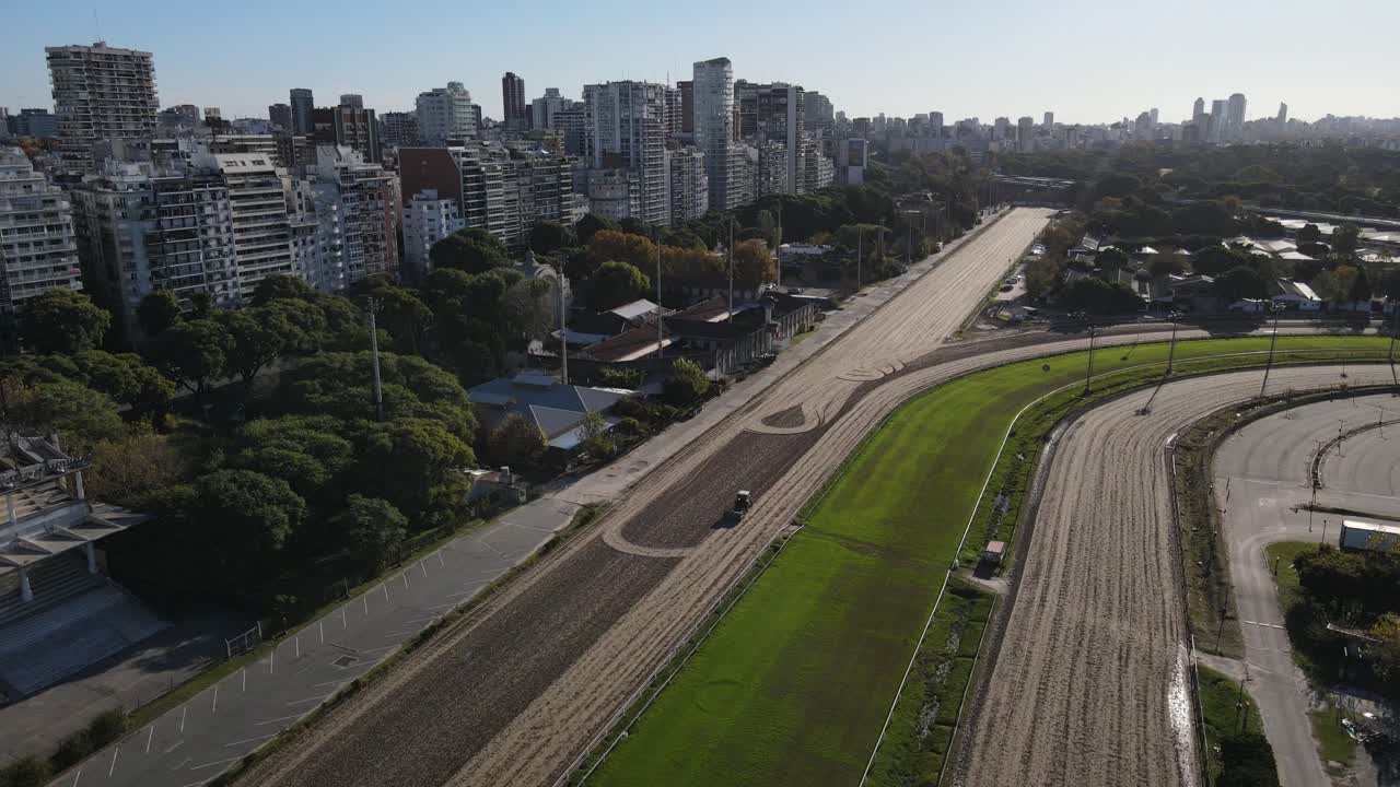 foto orbital aérea de trator preparando pista para corrida de cavalos em frente ao horizonte à luz do sol