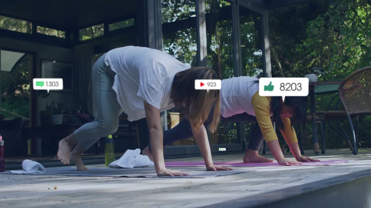 엄마와 딸이 분홍색 요가 매트에 올라선 채 다운독 자세를 하며 떠다니는 측정 지표를 생성하고 있어요.