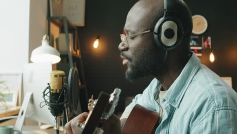 african american musician recording song at home studio