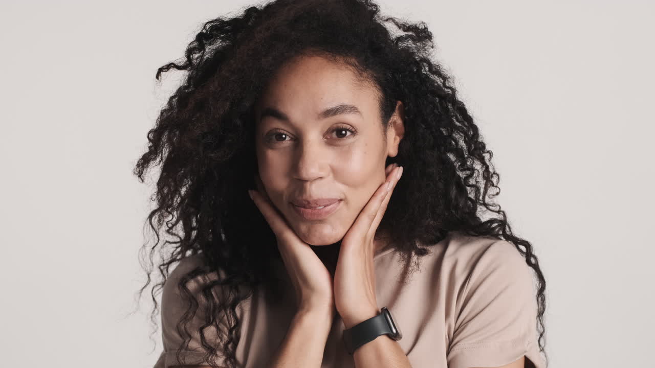 una mujer afroamericana encantadora sobre un fondo blanco.