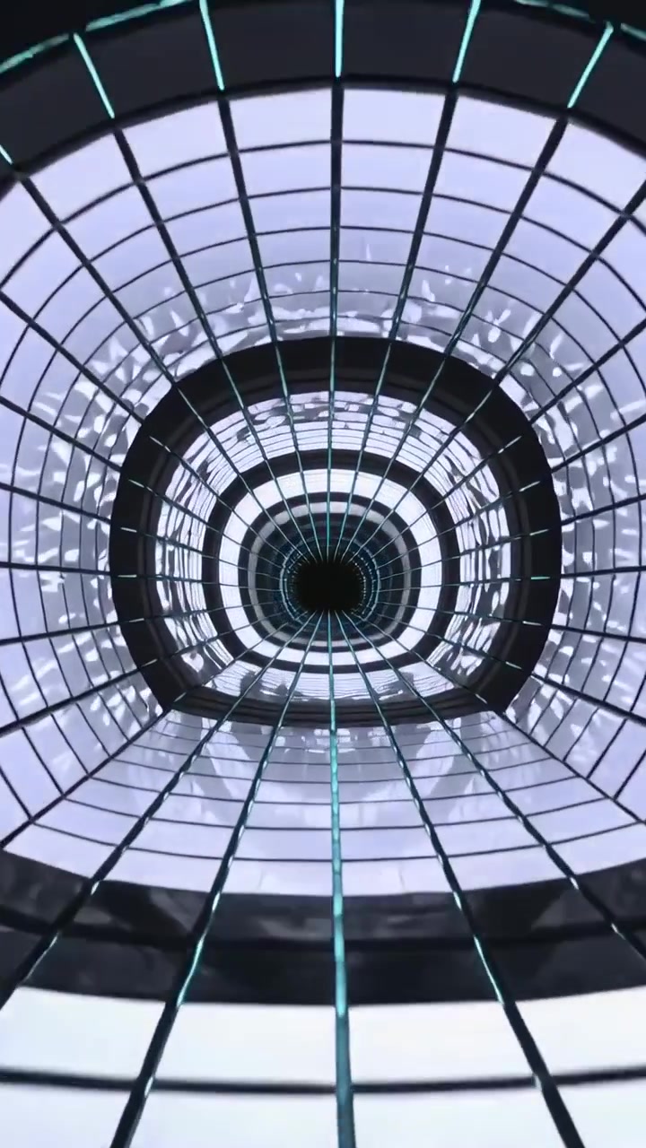Video verticale: La telecamera si allontana rivelando il vano dell'atrio con anelli illuminati, una griglia e una linea turchese.