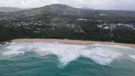 Playa-Idílica-Con-Olas-Espumosas-Del-Océano-Que-Se-Lavan-En-La-Costa-En-La-Playa-De-Zafiro,-Puerto-De-Coffs,-Nsw,-Australia---Toma-Aérea-De-Drones