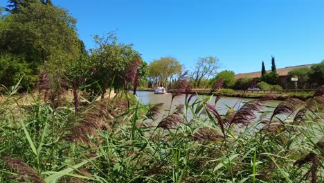 Barco-Turístico-Navegando-Por-El-Canal-Du-Midi-Francia-En-Un-Cálido-Día-De-Verano