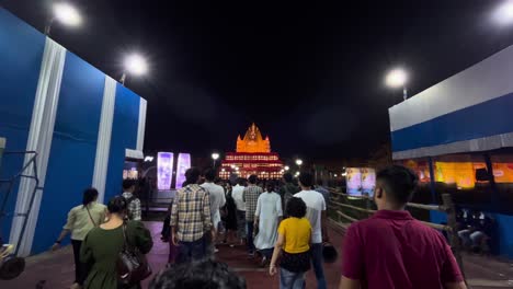 nighttime crowd entering illuminated temple or building