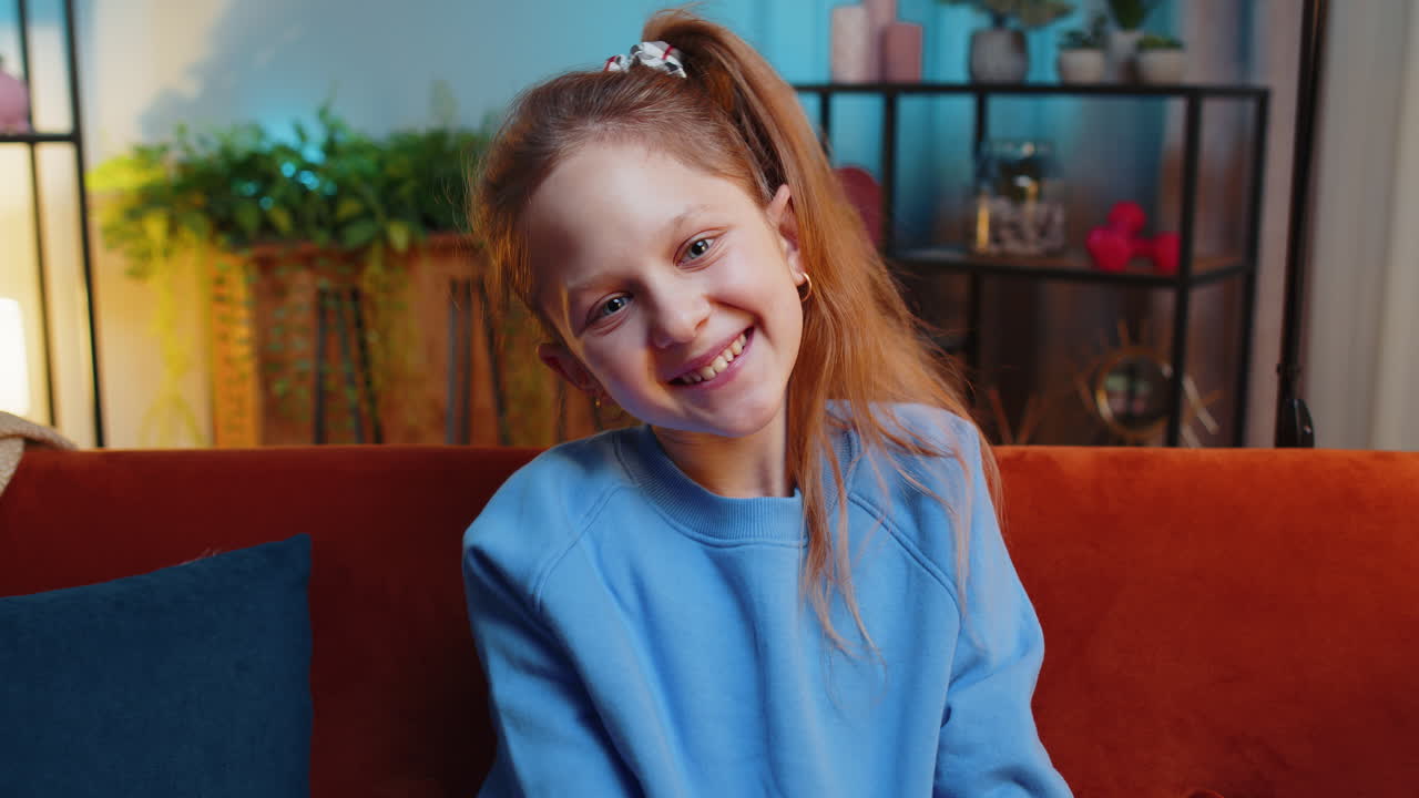 Portrait of happy smiling caucasian preteen school girl child kid looking at camera home play room