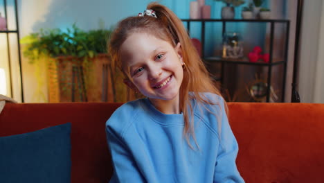 portrait of happy smiling caucasian preteen school girl child kid looking at camera home play room