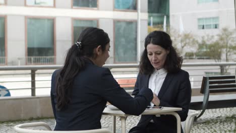 businesswomen with digital tablet in outdoor cafe