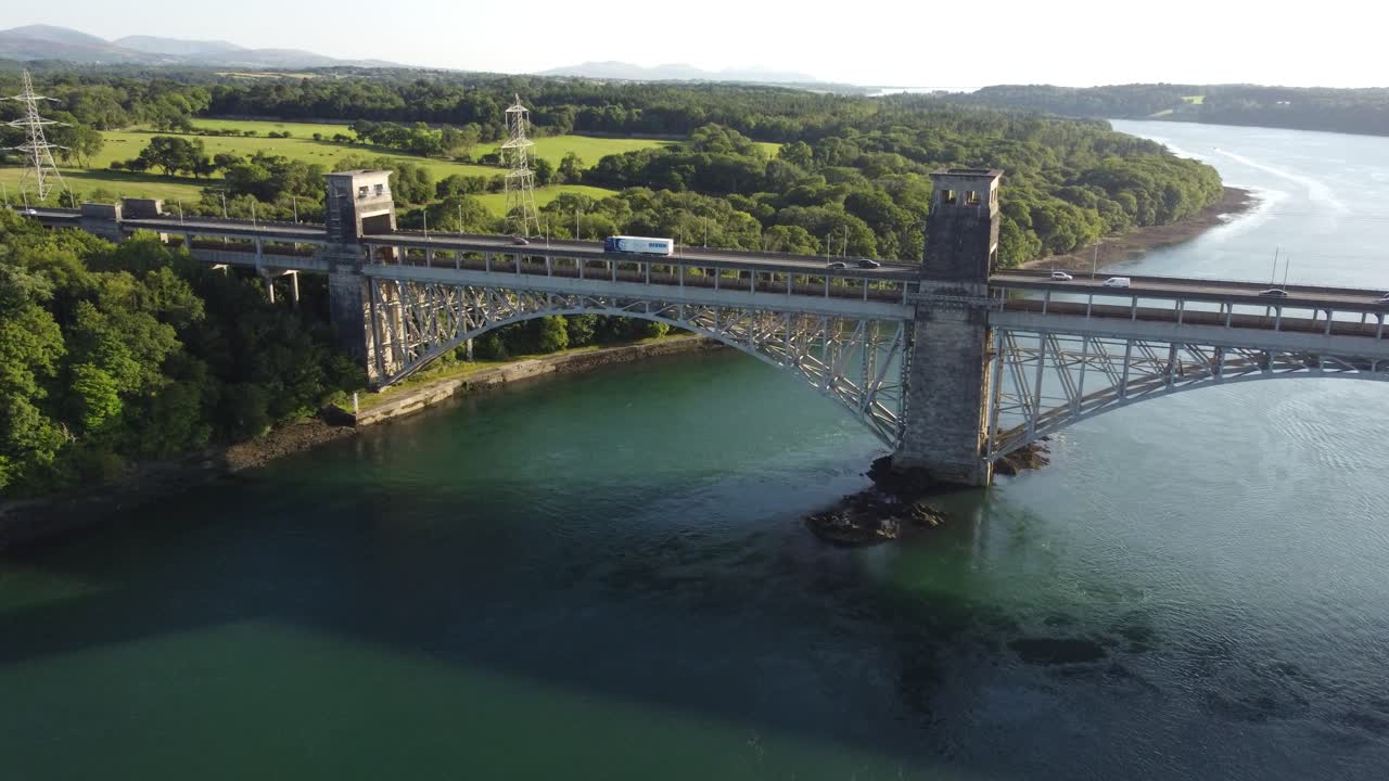 해질녘에 반짝이는 웨일스 메나이 해협을 가로지르는 퐁 브리타니아 다리를 향한 공중 전망