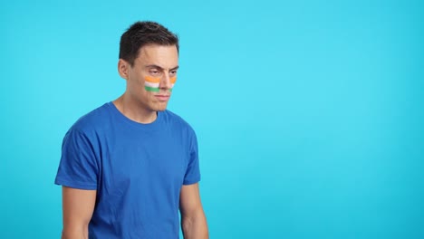 Happy man with indian flag painted on face looking away