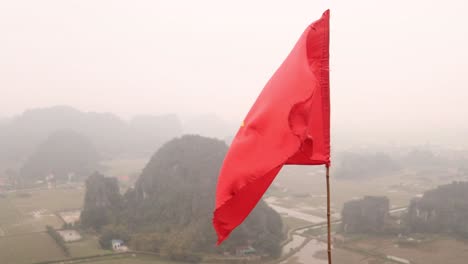 vietnamese flag waving in the wind above the river valley in the mountainous region of ninh ninh in northern vietnam