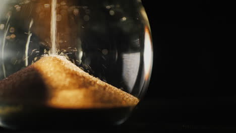 the lower part of the hourglass the little grains of sand fall from above