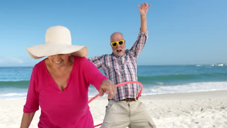 una pareja de mayores haciendo hula hoop.
