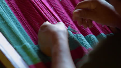 mujer indígena tejiendo una manta