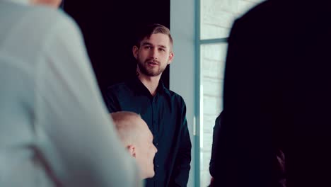 handsome young director communicates with business colleagues in a modern office