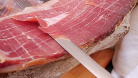 closeup shot, cured ham, spanish serrano ham, being sliced for tapas meal