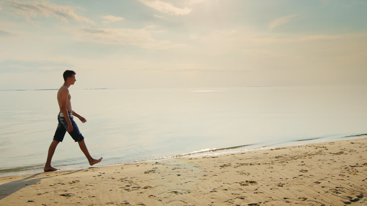 adolescente caminando por la playa al atardecer contra el telón de fondo del hermoso cielo nocturno