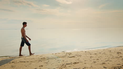 adolescente caminando por la playa al atardecer contra el telón de fondo del hermoso cielo nocturno