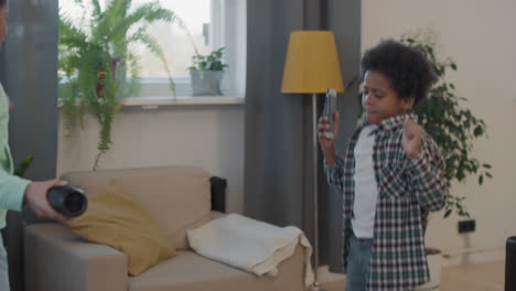 afro siblings dancing in living room