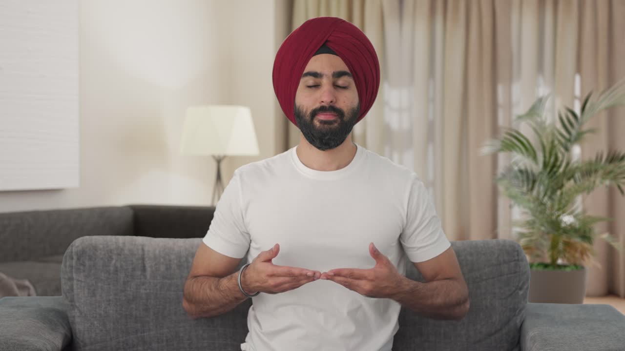 Uomo indiano Sikh felice che pratica yoga