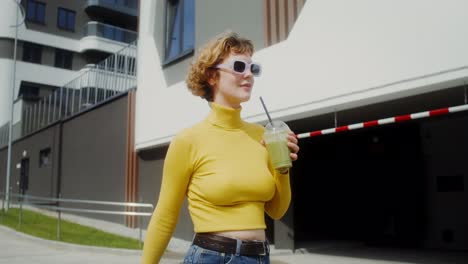 mujer bebiendo batido en la ciudad