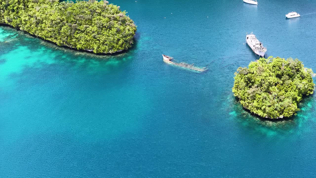 Høyt luftfoto av en hvit katamaran som seiler gjennom turkise tropiske lagunevann