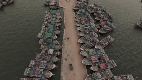 Aerial-Birds-Eye-View-Of-Fishing-Boats-Moored-Along-Jetty-At-Ibrahim-Hyderi-In-Karachi