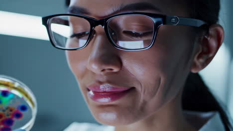 close-up of a scientist observing a petri dish in a lab