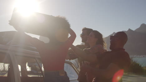 amigos cargando equipaje en el estante del techo del coche listos para el viaje por carretera