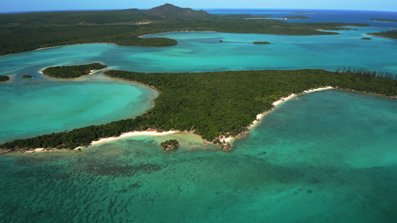 Aerial pullout over tropical island near Isle of Pines, Pic N’ga in background