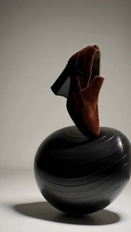 brown footwear balanced on a black exercise ball