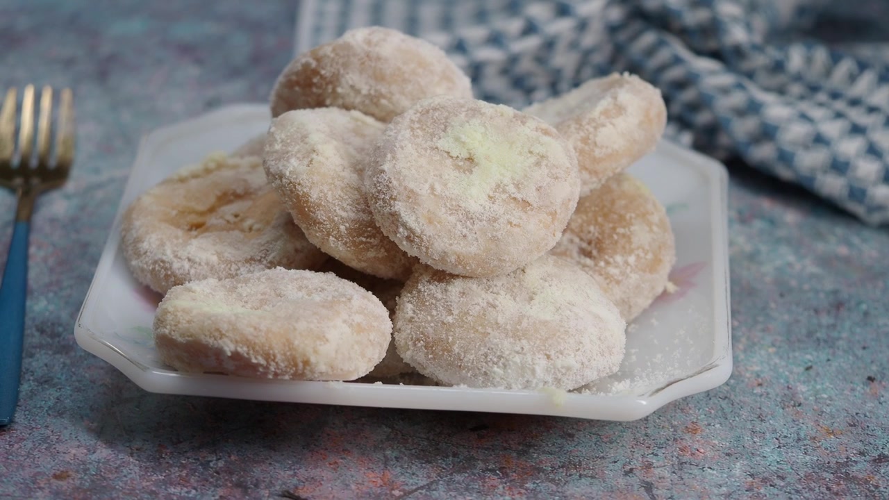 Piatto di deliziosi biscotti con zucchero a velo su una superficie testurizzata