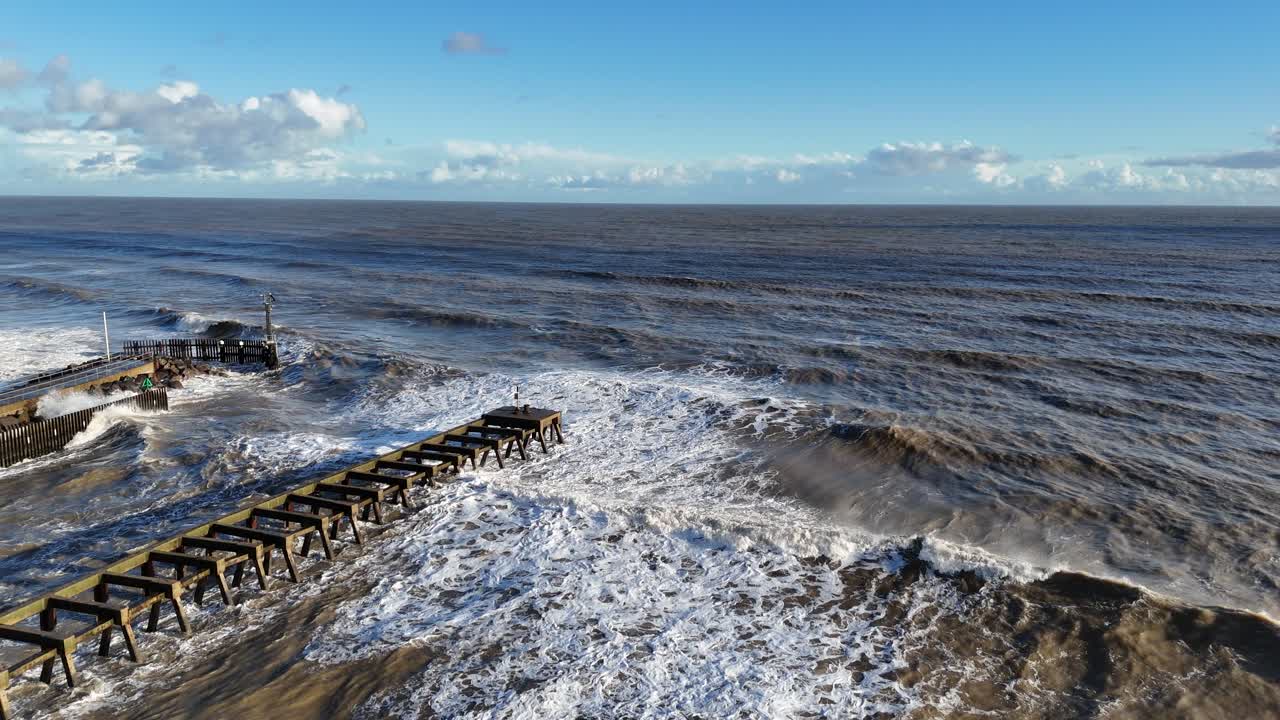 Waves breaking over abandond jetty drone,aerial