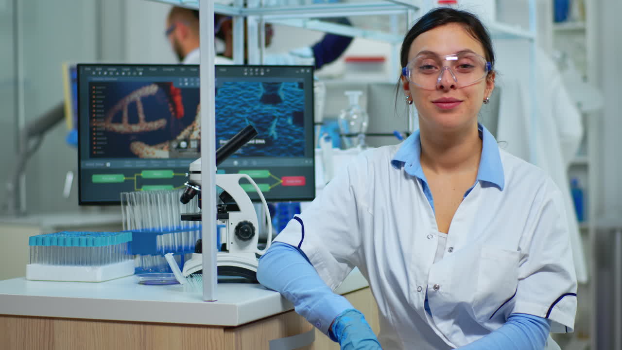 Portrait of scientist smiling at camera sitting in modern laboratory