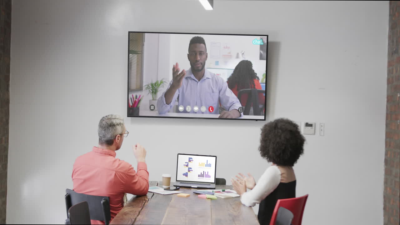 Diverse business people on video call with african american male colleague on screen