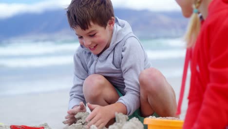 niños haciendo castillos de arena en la playa