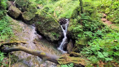 Establishing-shot,-flying-towards-uphill-torrential-stream-in-Hudicev-Graben,-Slovenia