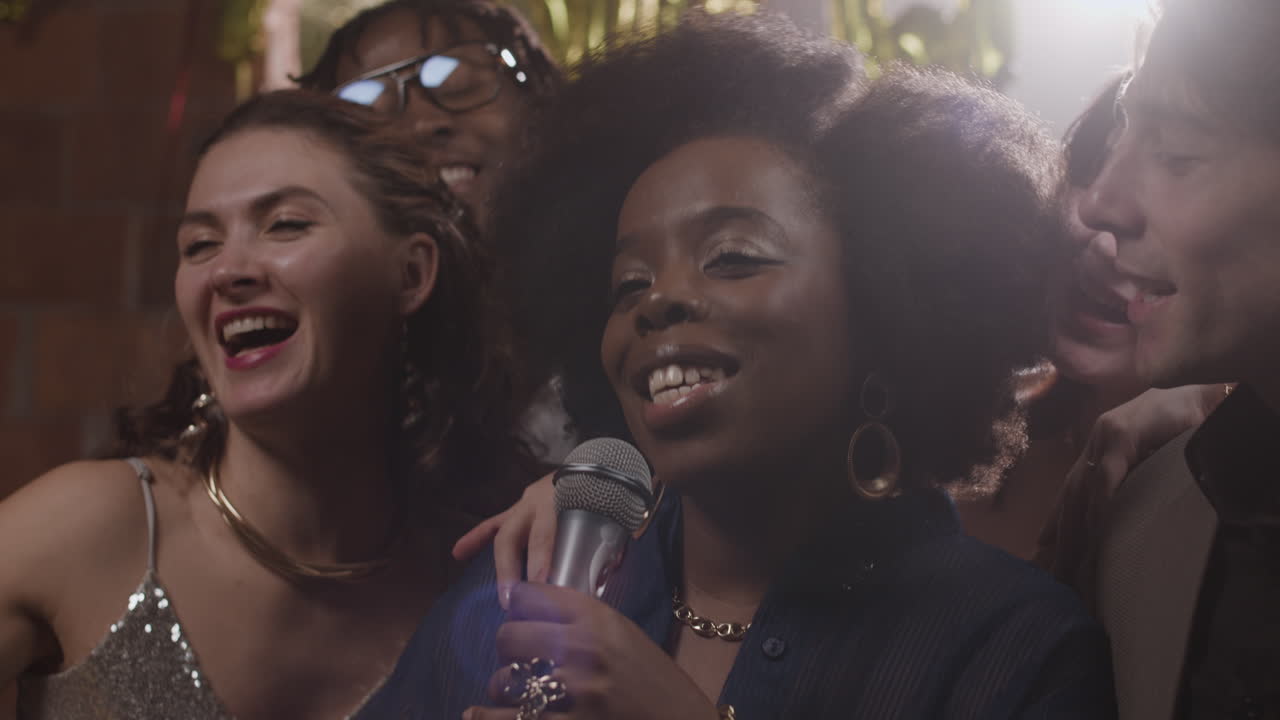 Group of friends singing karaoke at a party
