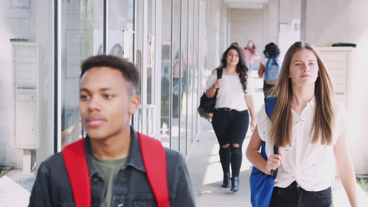 대학생들이 수업 사이에 캠퍼스 복도를 따라 고 있습니다.