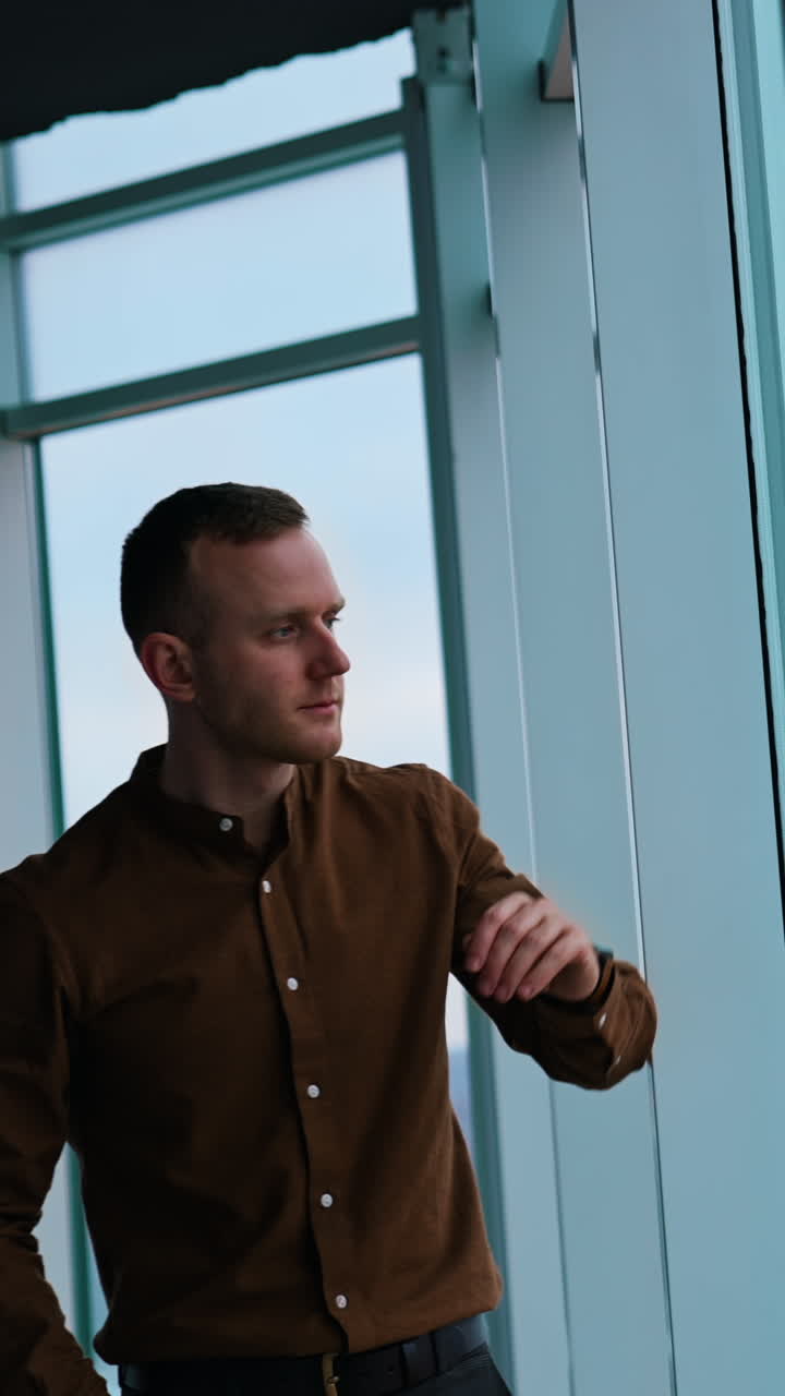 Businessman look through window when work in the night Vertical video