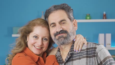 una pareja de mediana edad mirando a la cámara.