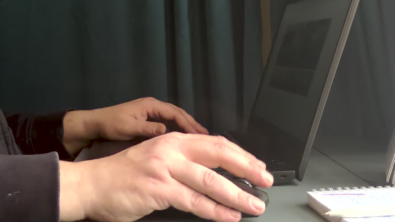 Uomo che digita sulla tastiera del portatile lavorando da casa. Un freelancer lavora su un portatile, primo piano. Type K