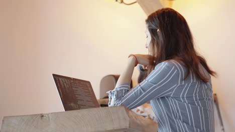 woman working on a laptop in a minimalist home office, symbolizing focus and productivity. calm and concentrated environment with neutral tones, clean setup, and soft lighting