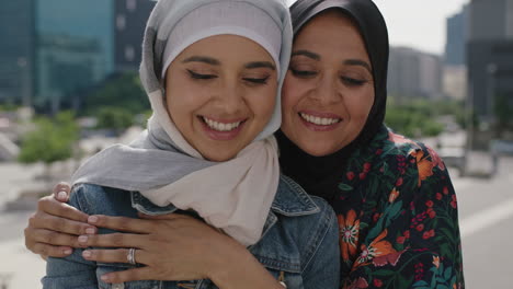 Nahaufnahme-Eines-Porträts-Einer-Muslimischen-Mutter-Und-Tochter,-Die-Fröhlich-Lächelnd-Umarmt-Und-In-Einer-Sonnigen-Stadt-Mit-Dem-Smartphone-Ein-Selfie-Foto-Macht