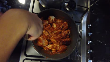 Top-Shot-of-Chef-Stirring-Chicken-into-Curry-Paste-During-Preparation-of-Vindaloo-During-Cooking-Class-at-Munnar,-Kerala,-India