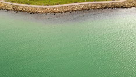 Aerial-view-of-pathway-by-coastline-with-rocks