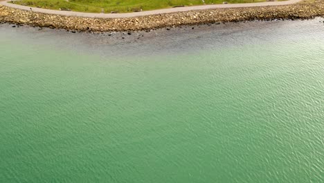 aerial view of pathway by coastline with rocks