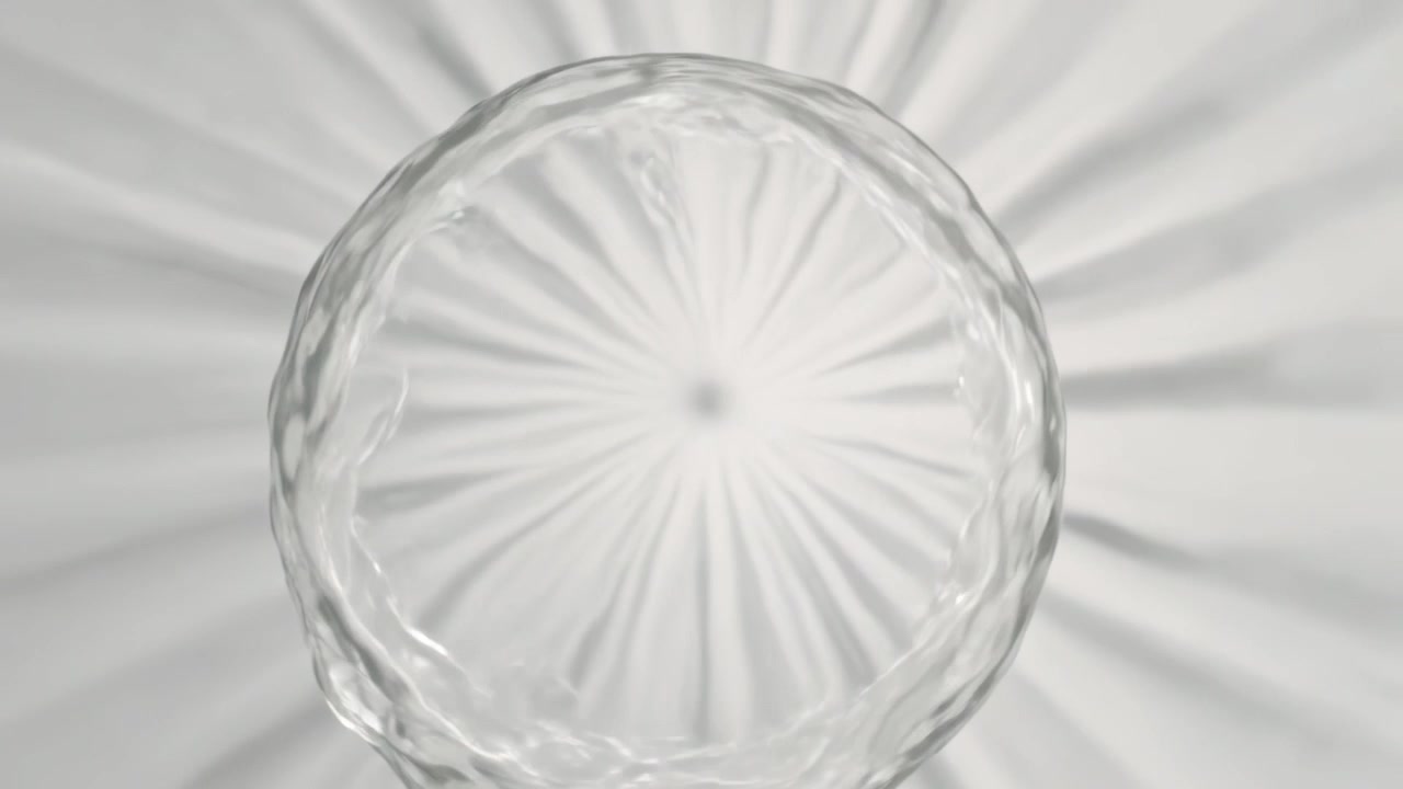 Shifting ribbed glass dish rotating subtly on white table, overhead light making starburst shadows