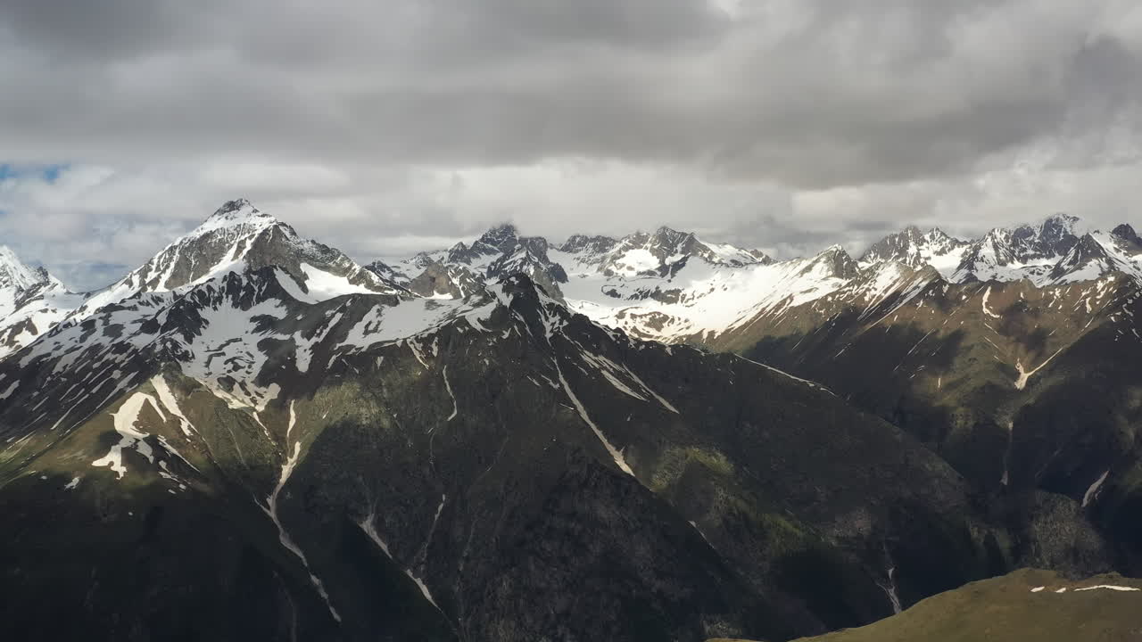 vuelo aéreo a través de nubes montañosas sobre hermosos picos nevados de montañas y glaciares.