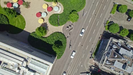 aerial view over city of zürich with roofs, main road and park with colorful sunshades on a sunny and cloudy spring day.