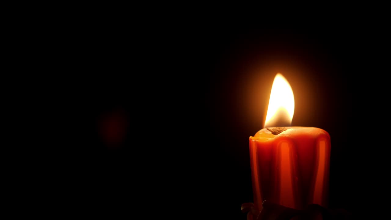 cerca de la vela ardiente oscuridad negra. luz fuego vela de cera soplando en la oscuridad completa. oración, fe, tristeza, memoria o concepto romántico